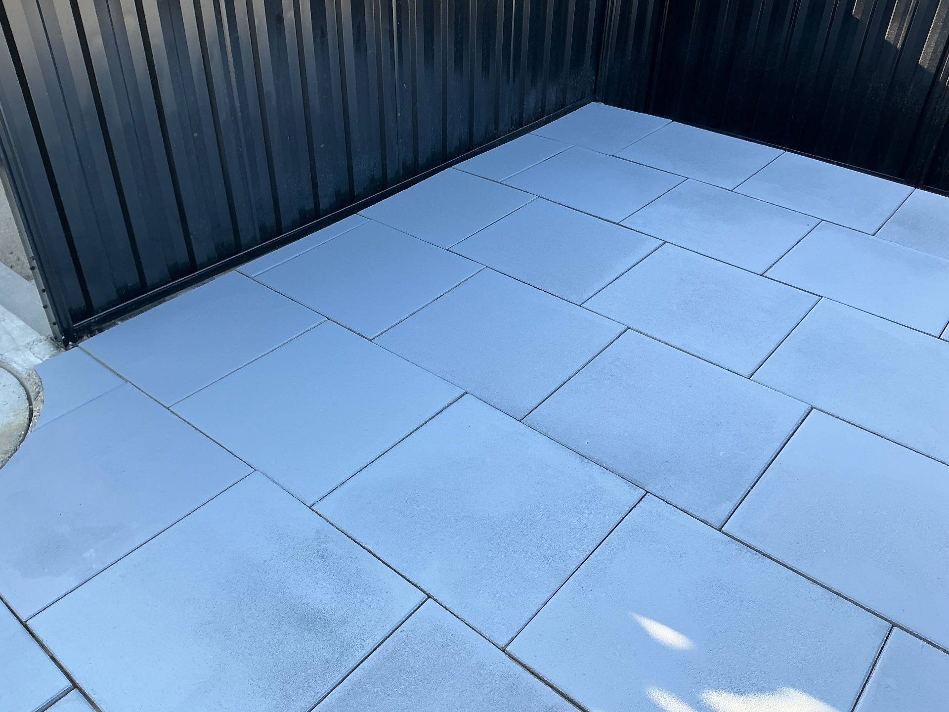 Finished slabs meeting the back fence corner with a clean edge cut