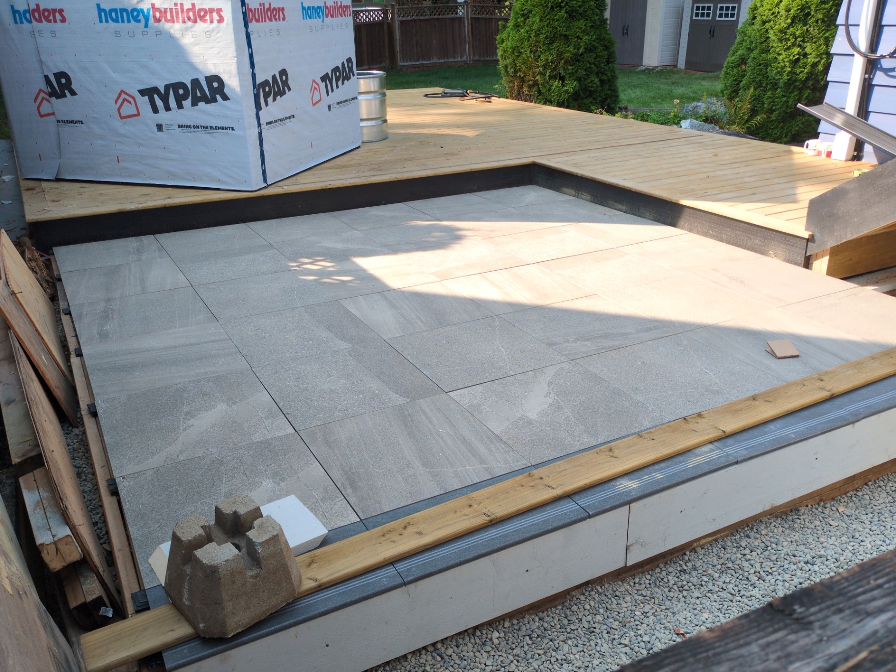 Finished slab patio meeting the new cedar deck where it steps down off the house