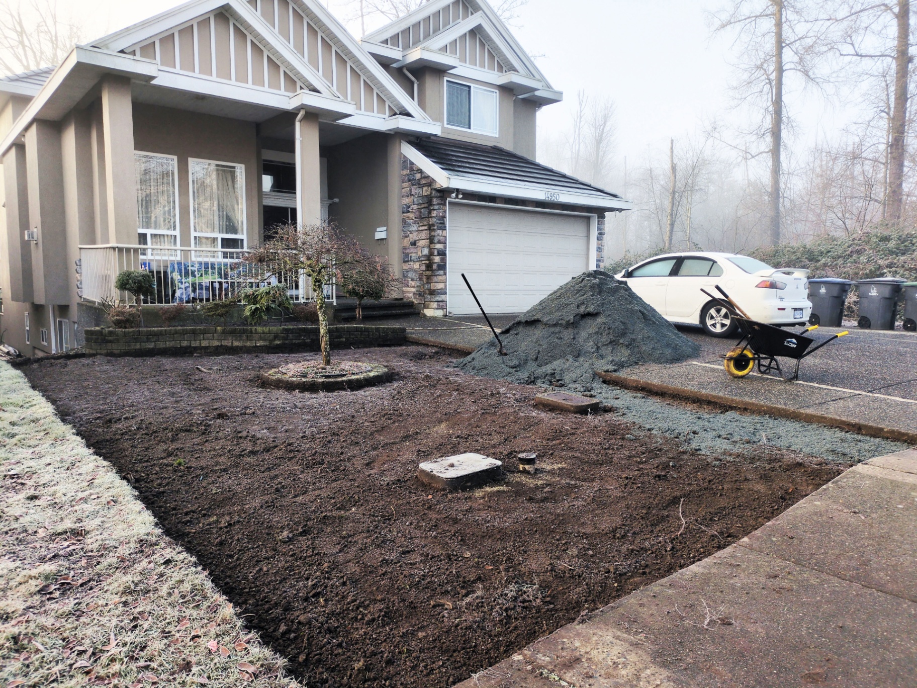 Front yard stripped to soil with bedding sand piled and ready