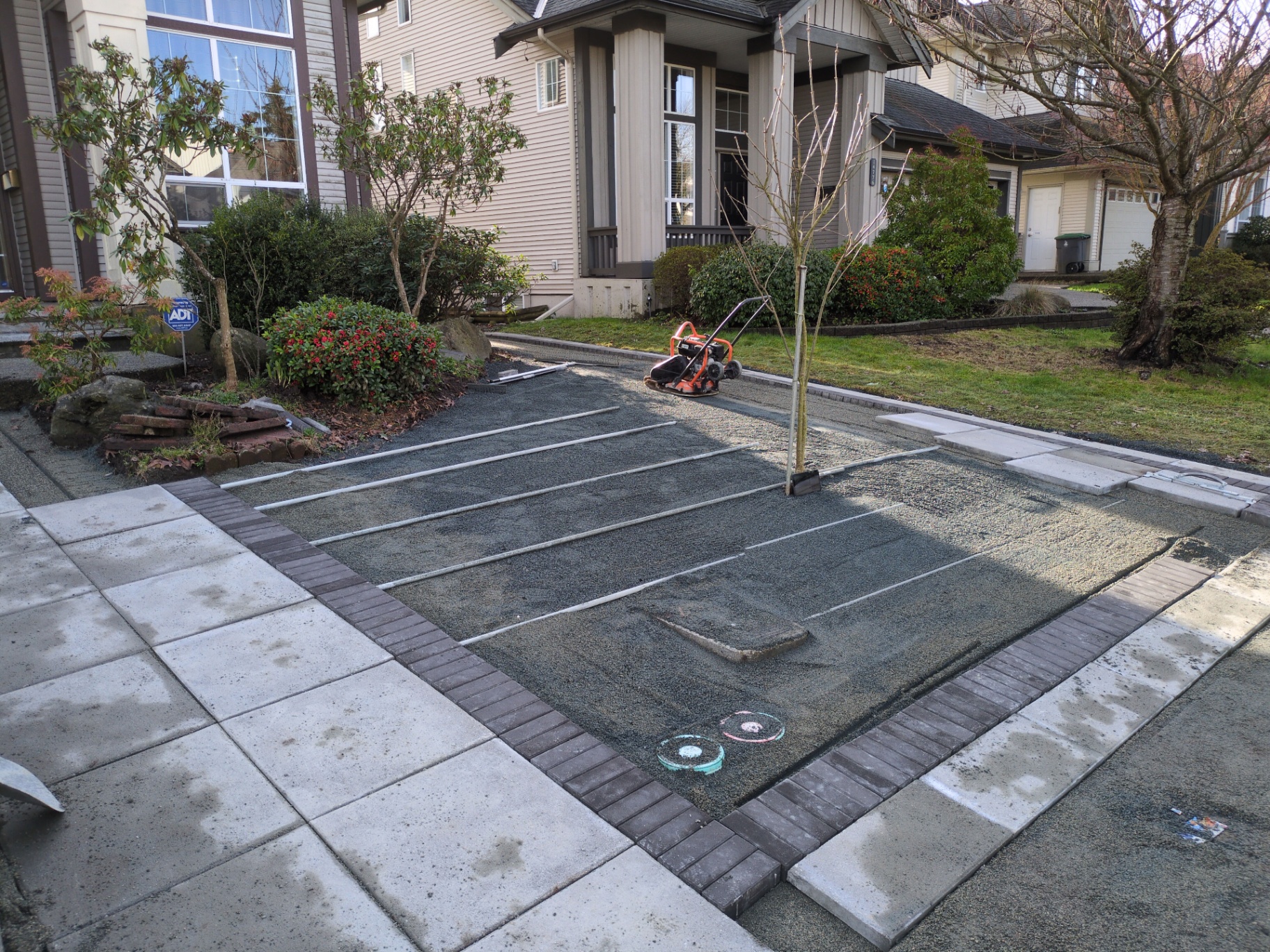 Compacted base with screed rails set across the prepared driveway pad