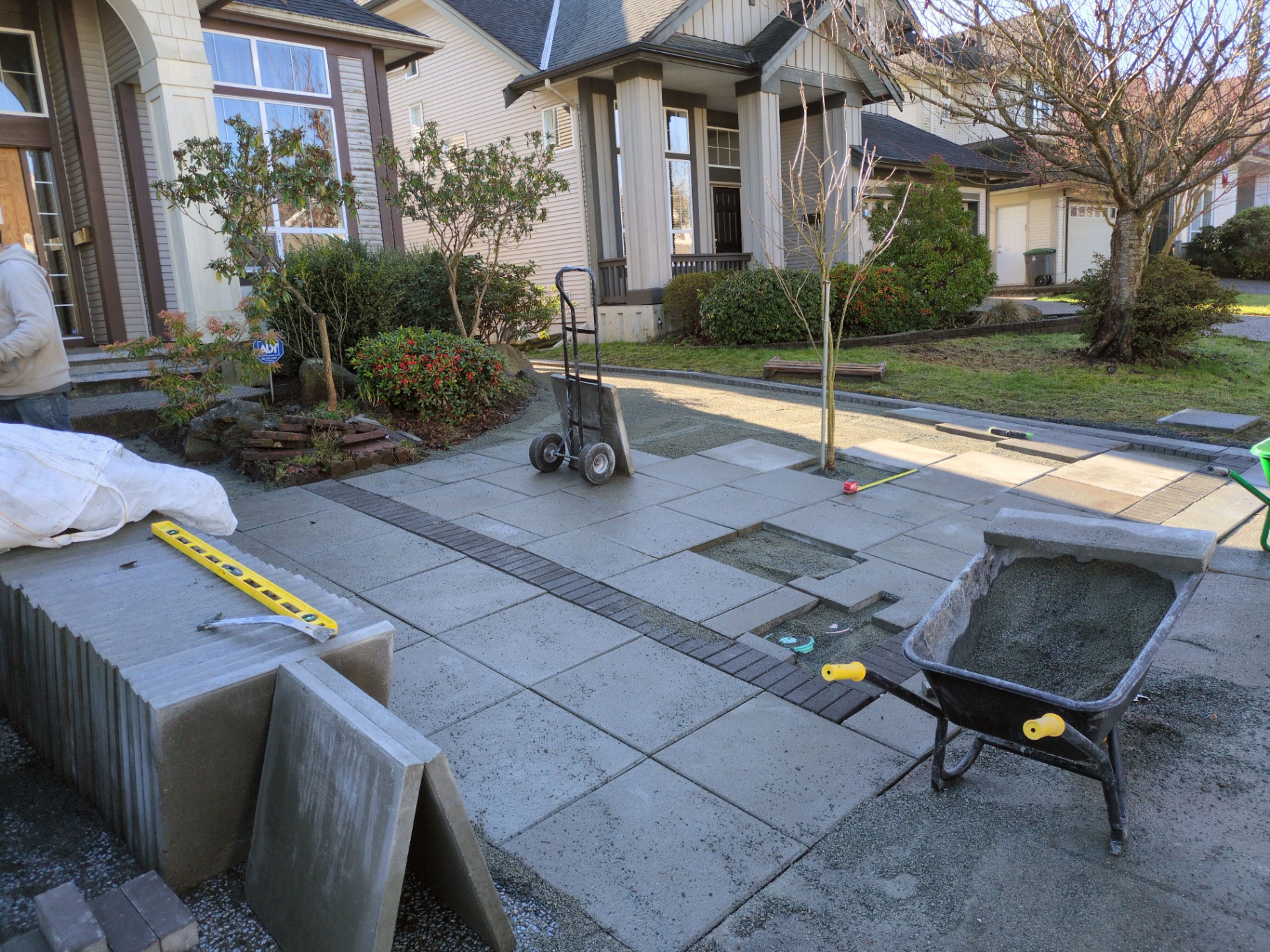 Slab pavers being laid across the driveway with charcoal accent band running through