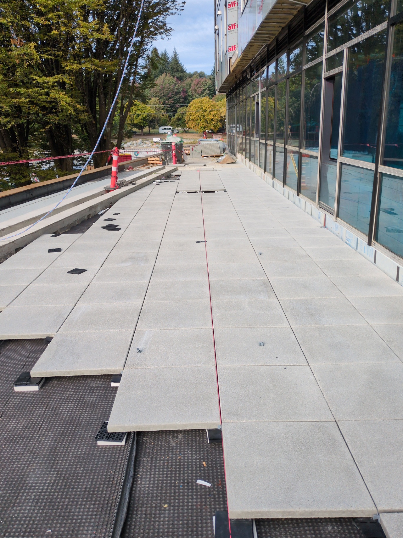 Walkway pavers being aligned along the building edge with laser line